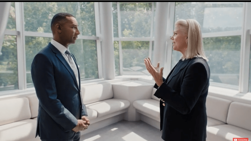 A man and woman talking in an office.