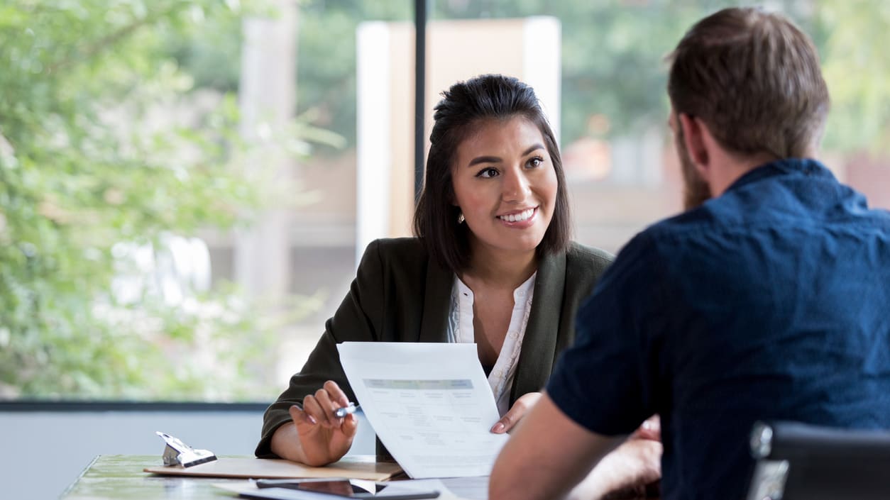 A man and woman are having a conversation in an office.