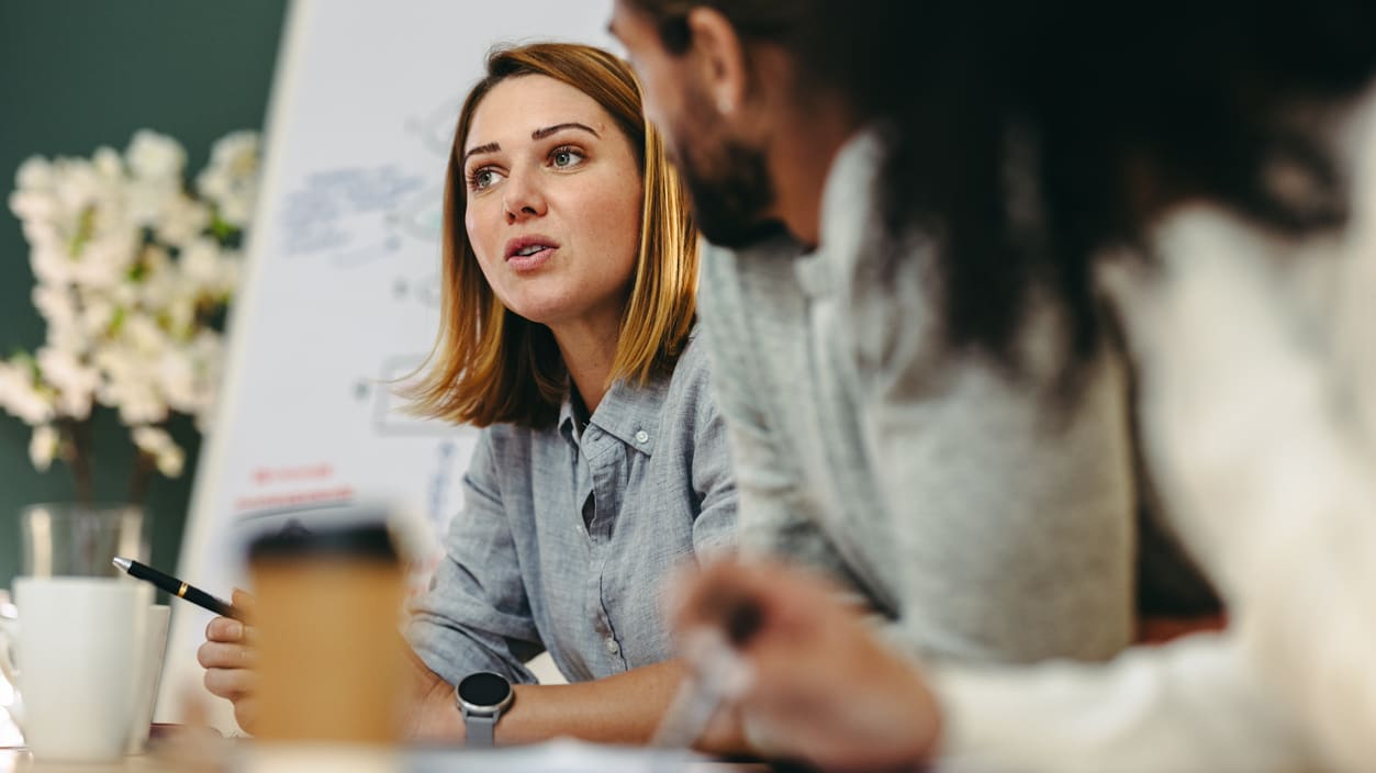 A group of people sitting around a table in a meeting.