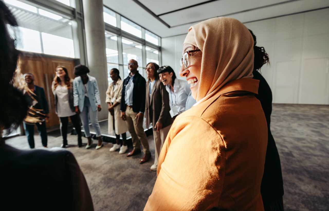 A diverse team celebrates together and finds community at work.