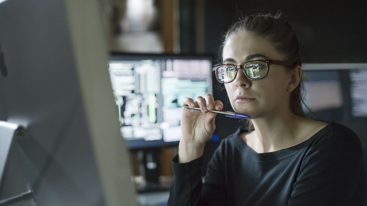 A woman in glasses sitting in front of a computer.