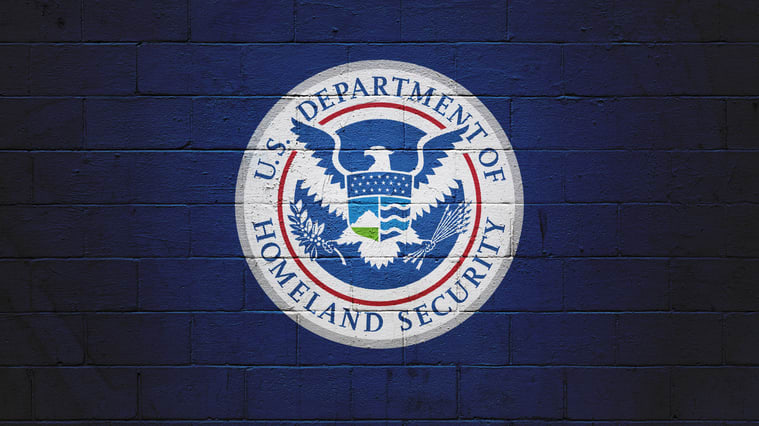 The u s department of homeland security logo on a brick wall.