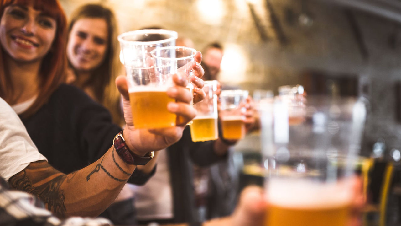 A group of people drinking beer in a bar.