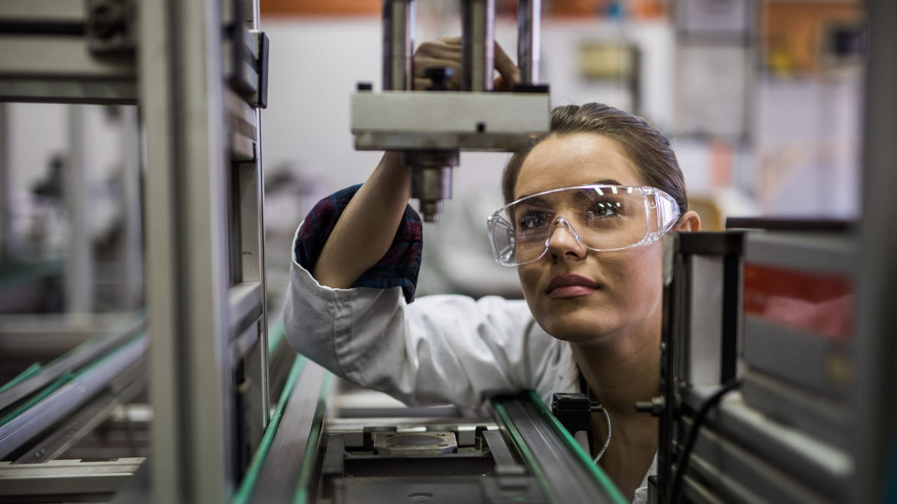 A woman working on a machine in a factory.