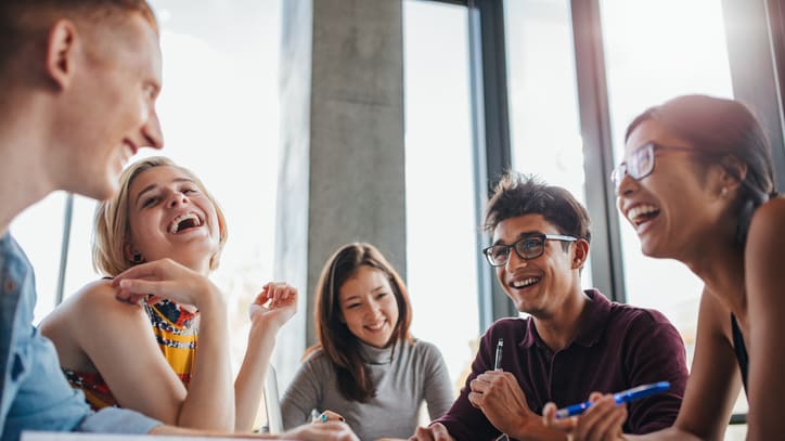 A group of people laughing around a table.