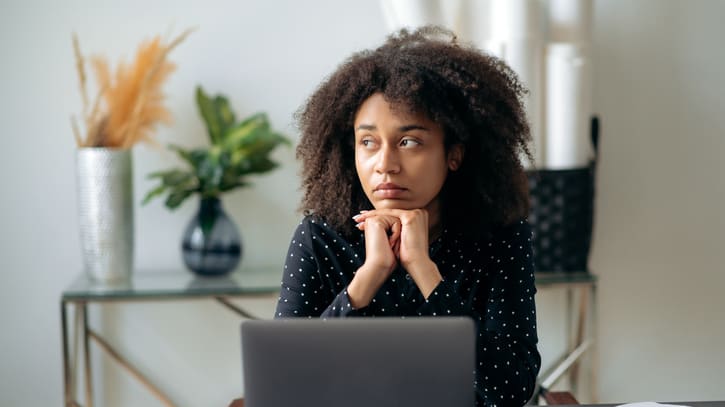 A woman sitting at a desk with a laptop in front of her.