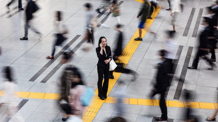 A blurry image of a group of people crossing a busy street.