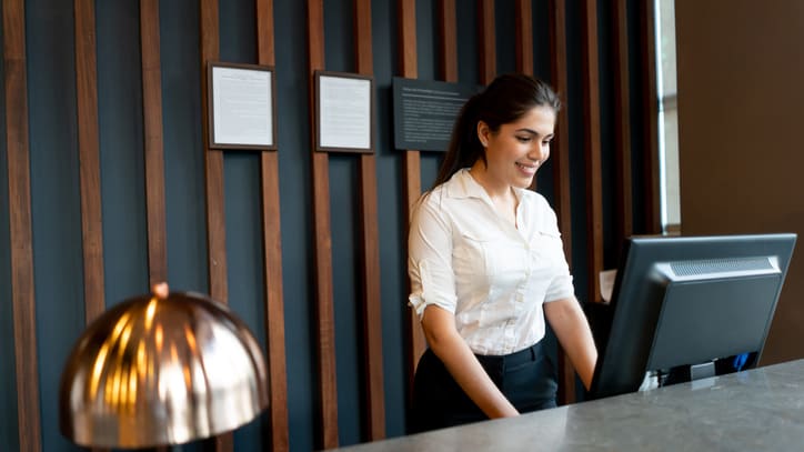 A woman at the front desk of a hotel.