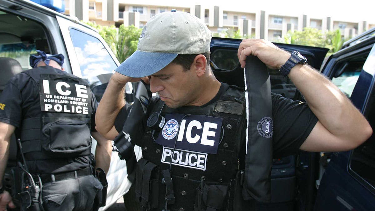 Two ice officers standing in front of a van.