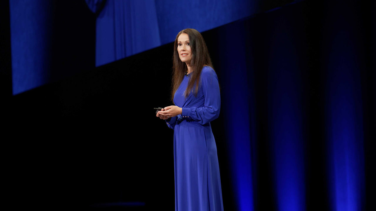 A woman in a blue dress standing on stage.