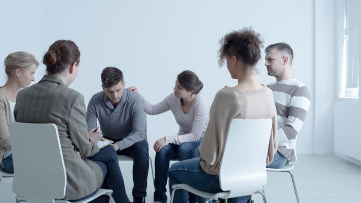 A group of people sitting around a table in a room.