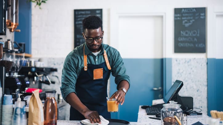 A man preparing food in a coffee shop.