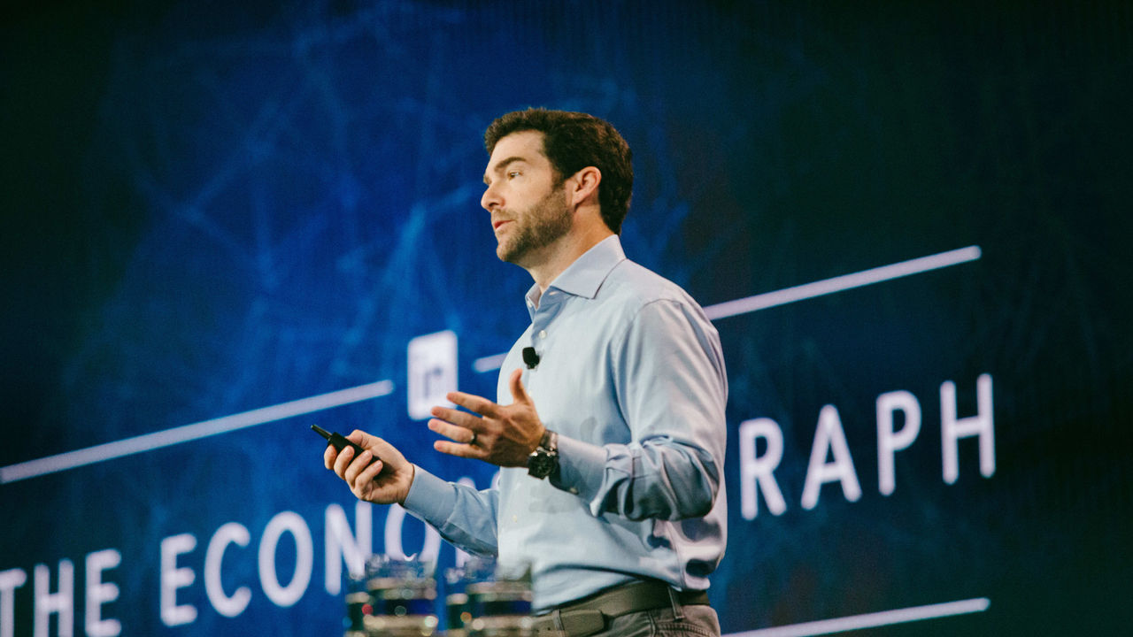 A man giving a presentation on the economic graph.