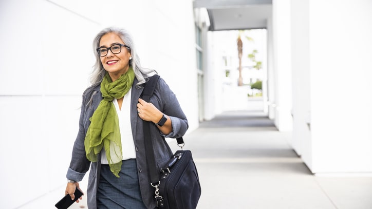 A business woman walking down the street with a briefcase.