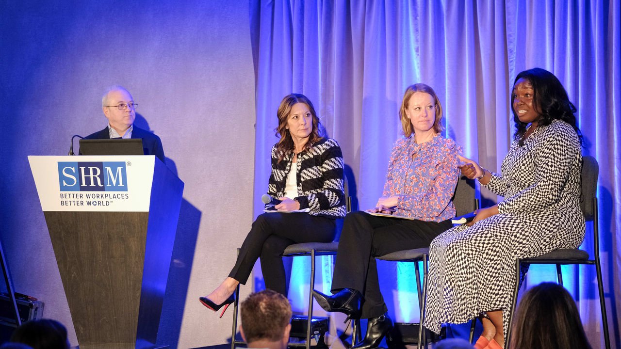 A group of people sitting on stage at an event.