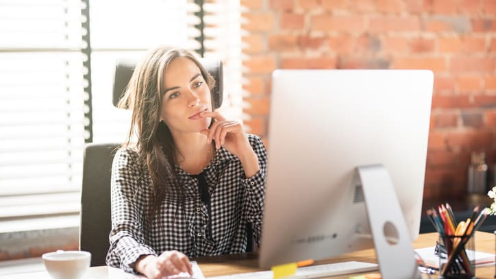 A woman sitting at a desk in front of a computer.