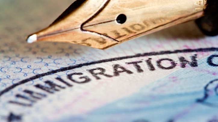 A fountain pen sits on top of a passport.