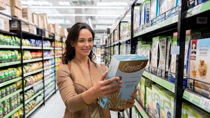 A woman shopping in a supermarket aisle.