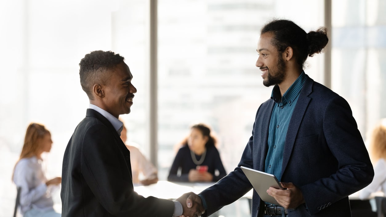 Two business people shaking hands in an office.