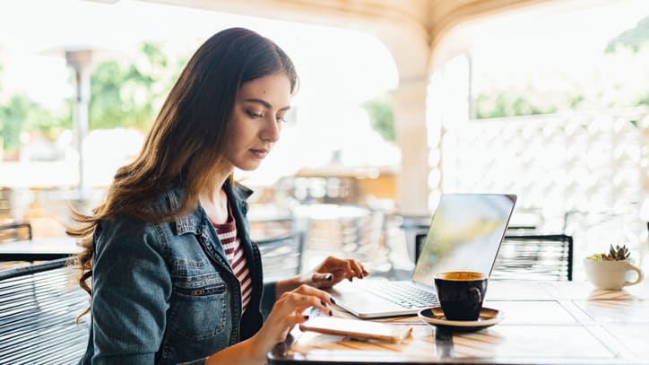 A woman working on her laptop in a cafe.