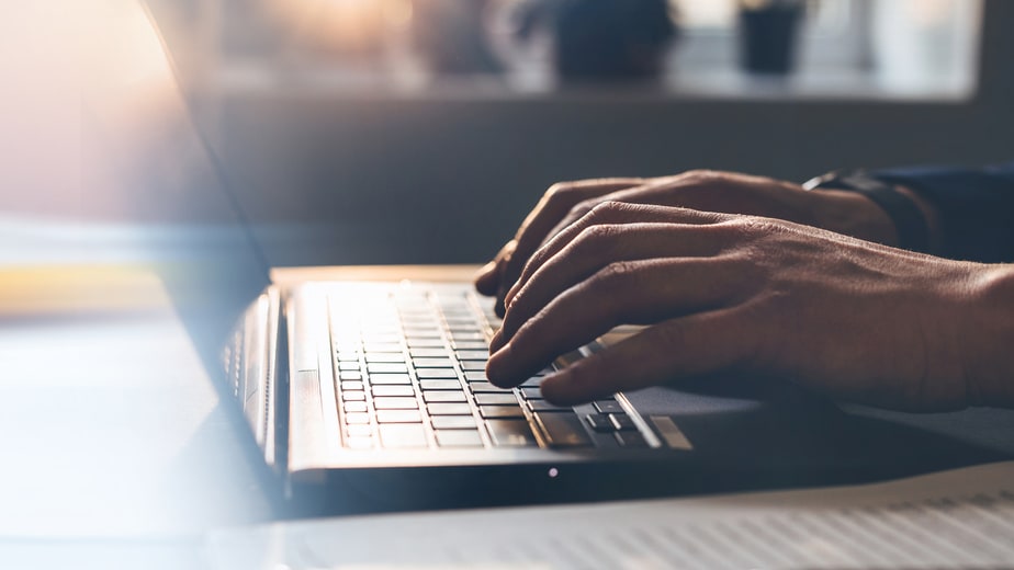 A person typing on a laptop with blurred background.