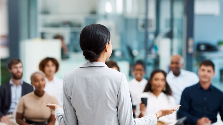 A woman is giving a presentation to a group of people.