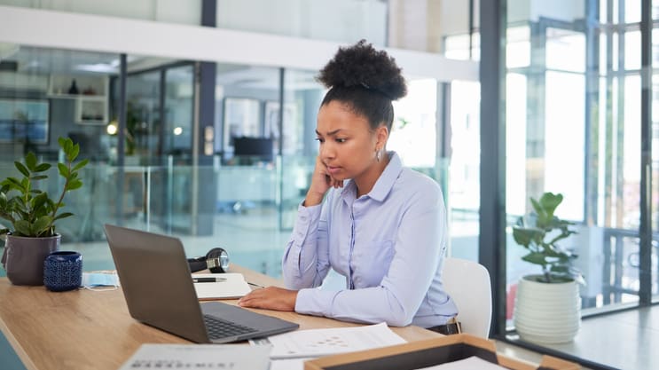 A woman sitting at a desk working on her laptop.