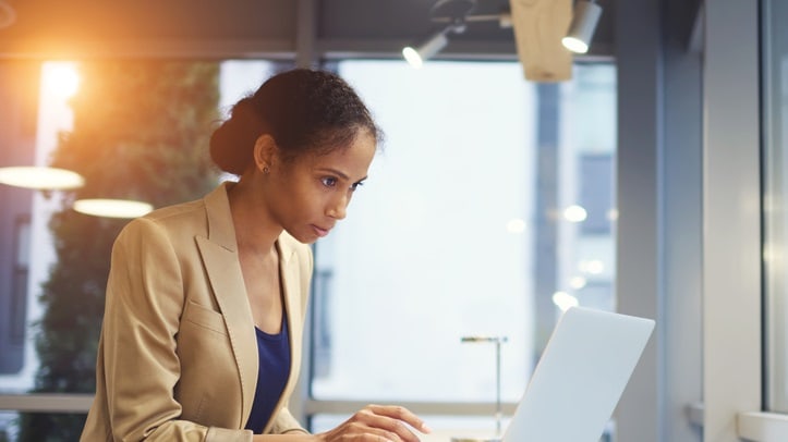 A business woman working on her laptop in an office.