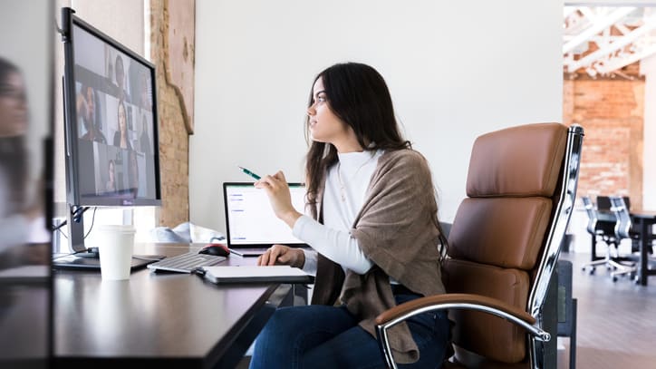 A woman sitting in a chair in front of a computer.