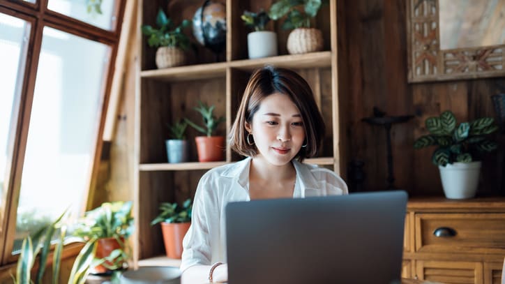 A woman sitting at a table using a laptop.