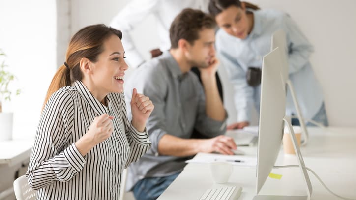 A group of people celebrating in an office.