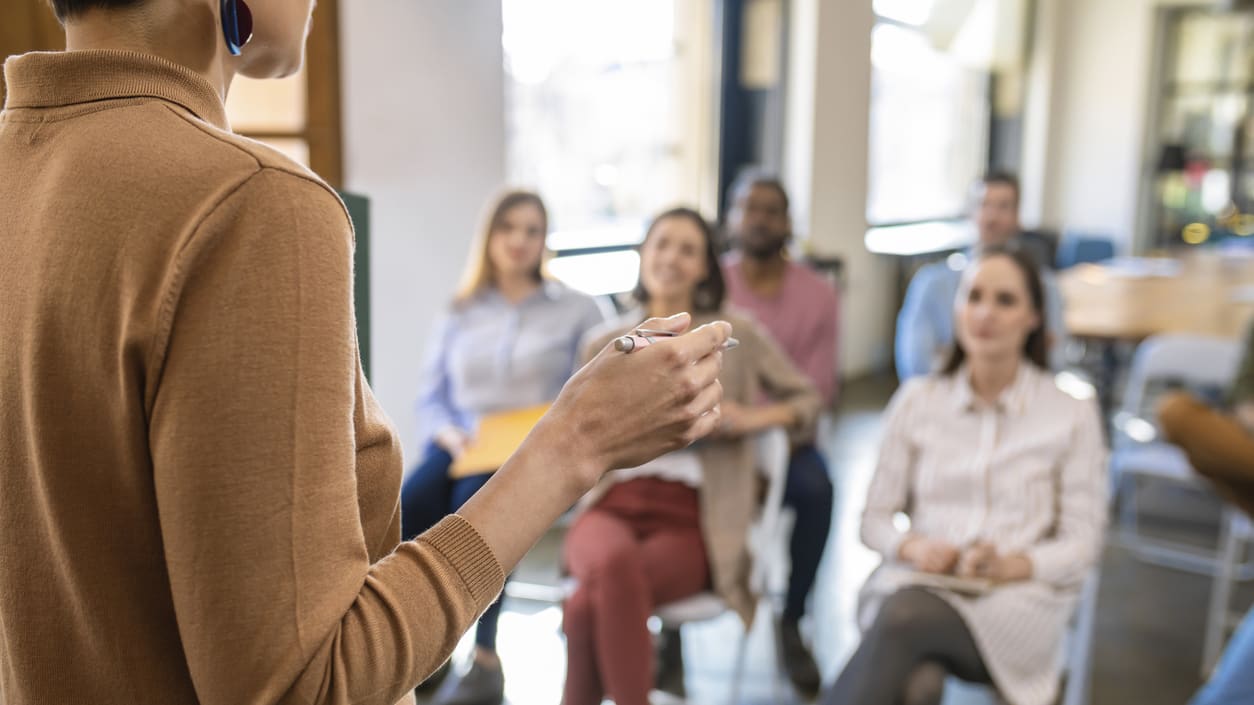 A woman giving a presentation to a group of people.