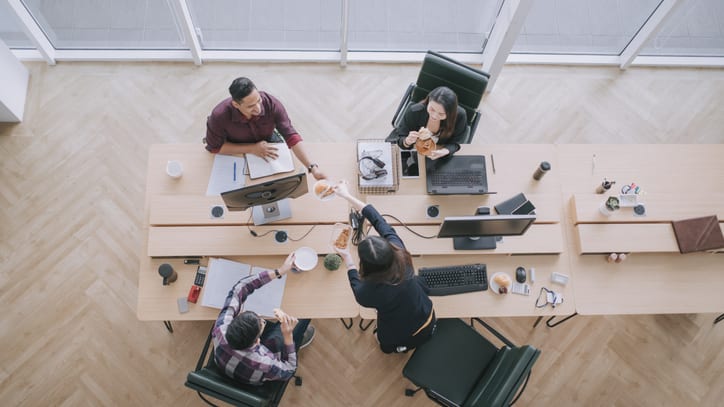 A group of people working at a desk in an office.