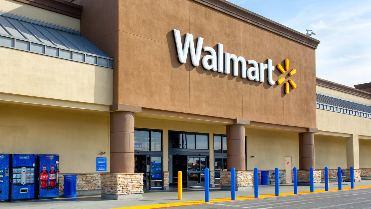 A picture of a walmart store with a parking lot.