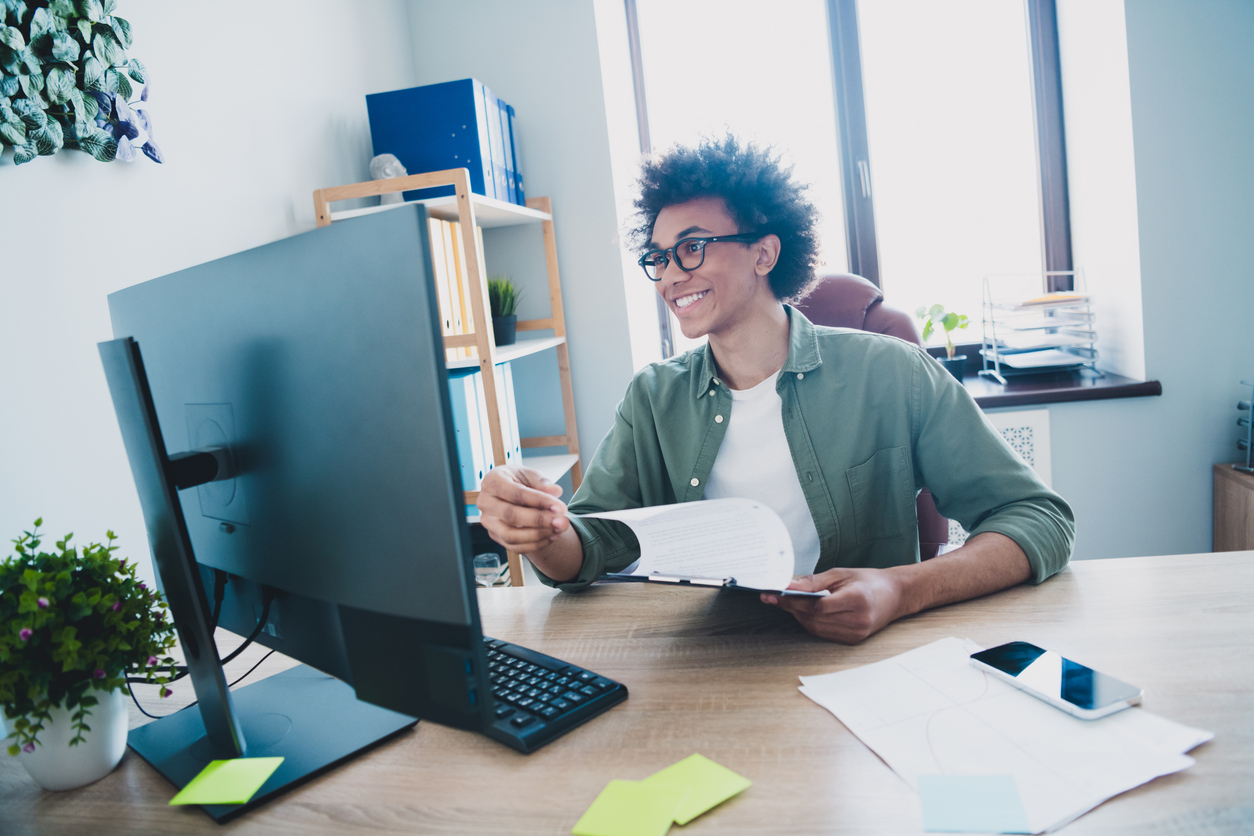 Photo of happy positive broker wear khaki shirt spectacles preparing contract reading modern device indoors workshop workstation.