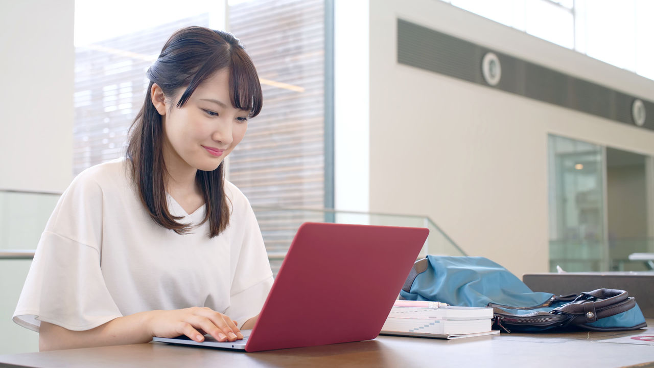 A young woman using a laptop in a library.