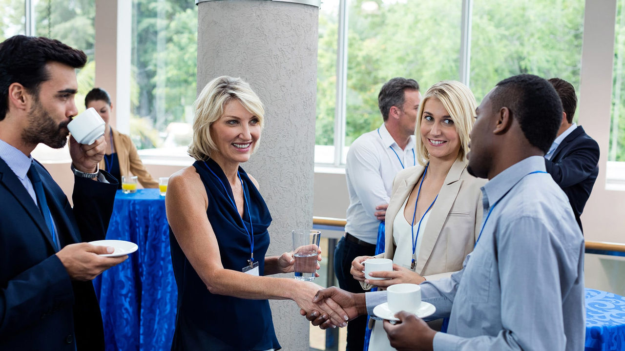 A group of people shaking hands at a business event.