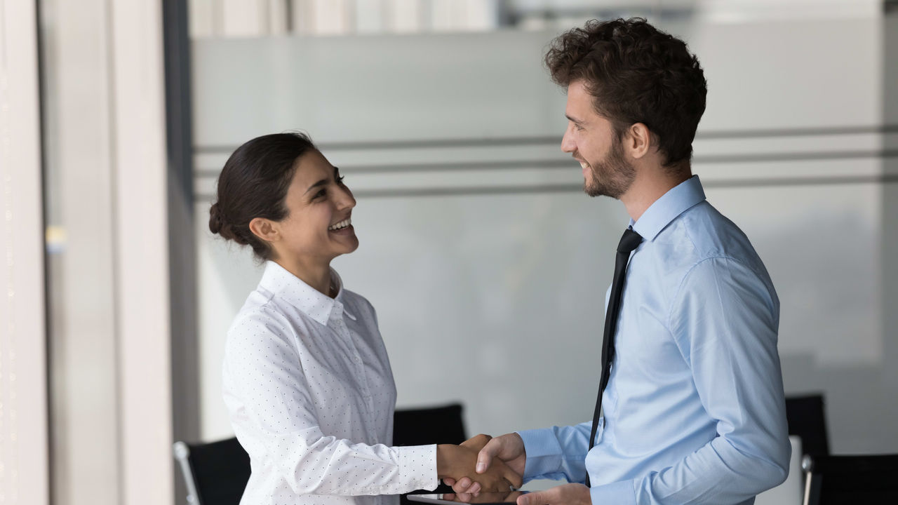 Two business people shaking hands in an office.