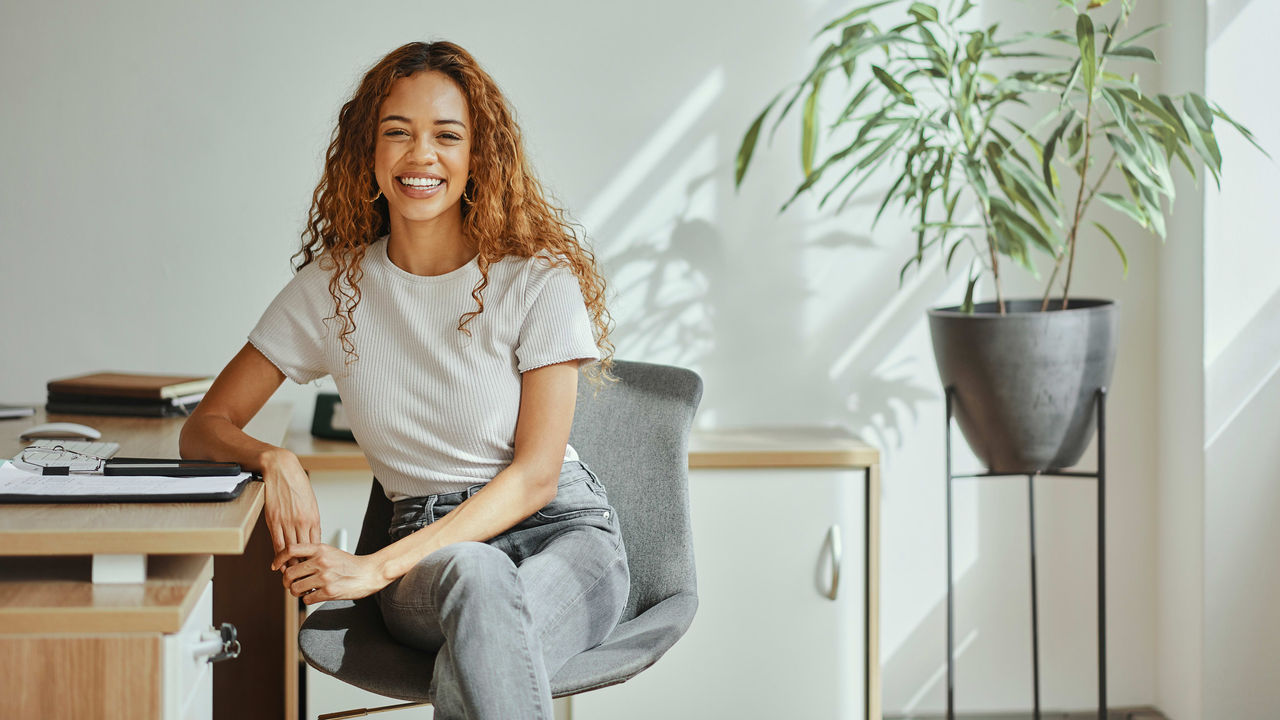 A young woman sitting at a desk in an office.