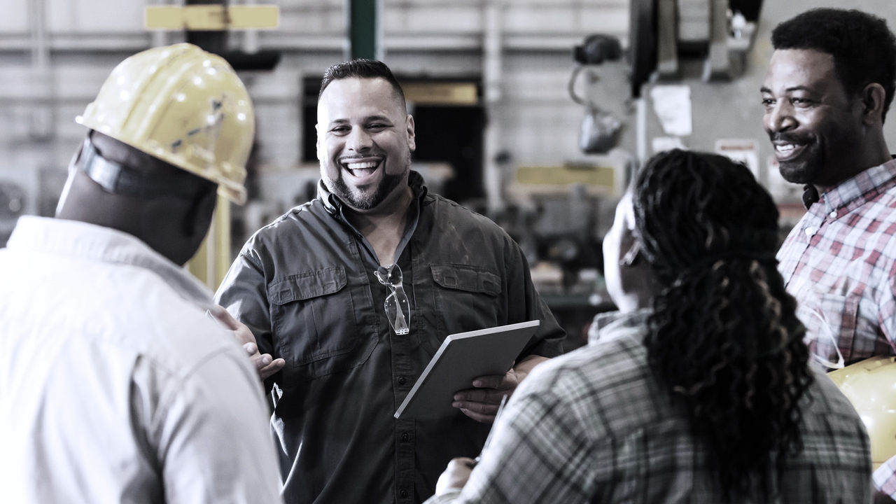 Coworkers standing together smiling at warehouse