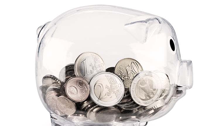 A piggy bank filled with coins on a white background.