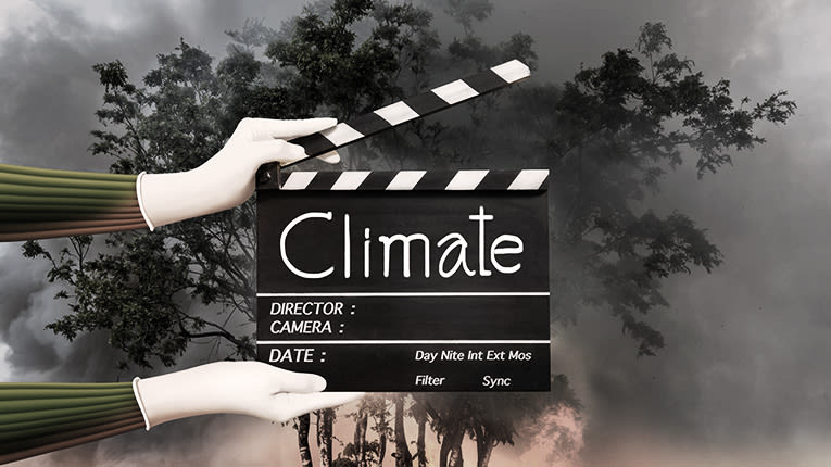 A person holding a clapper board with the word climate.