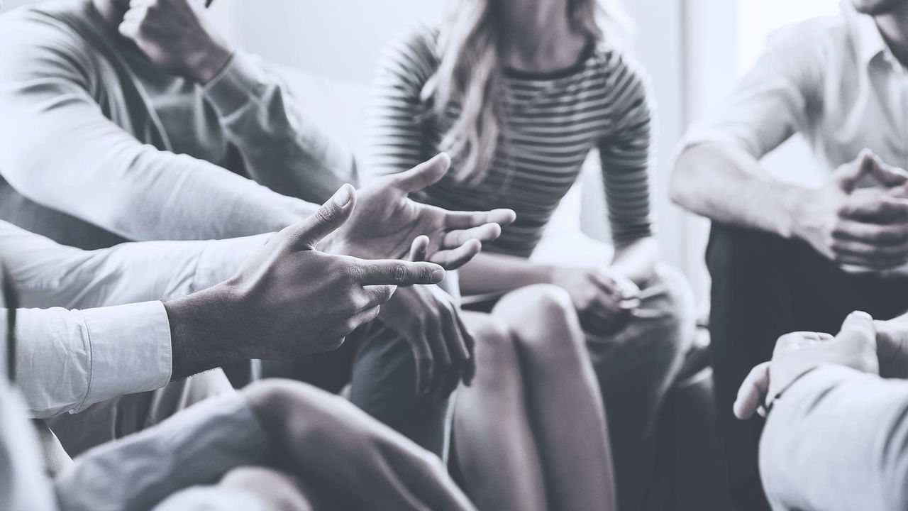 A group of people sitting around a table and talking.