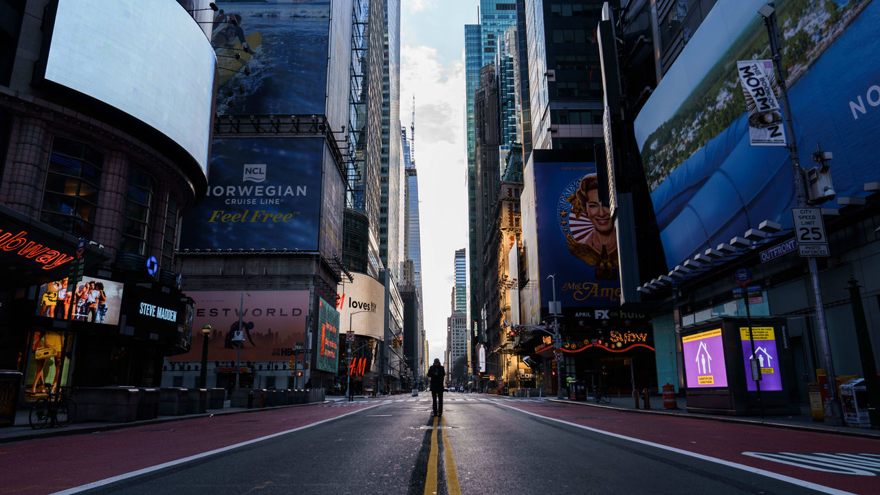 A man is walking down an empty street in new york city.