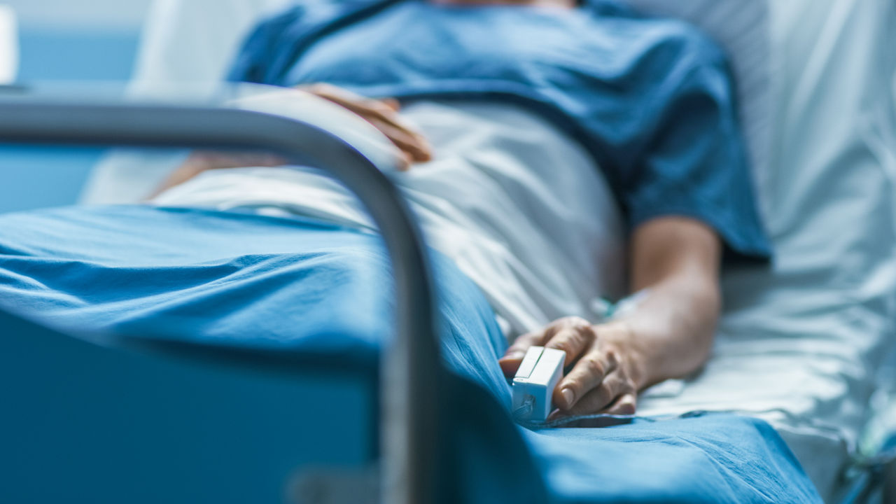 Patient in blue gown in hospital bed