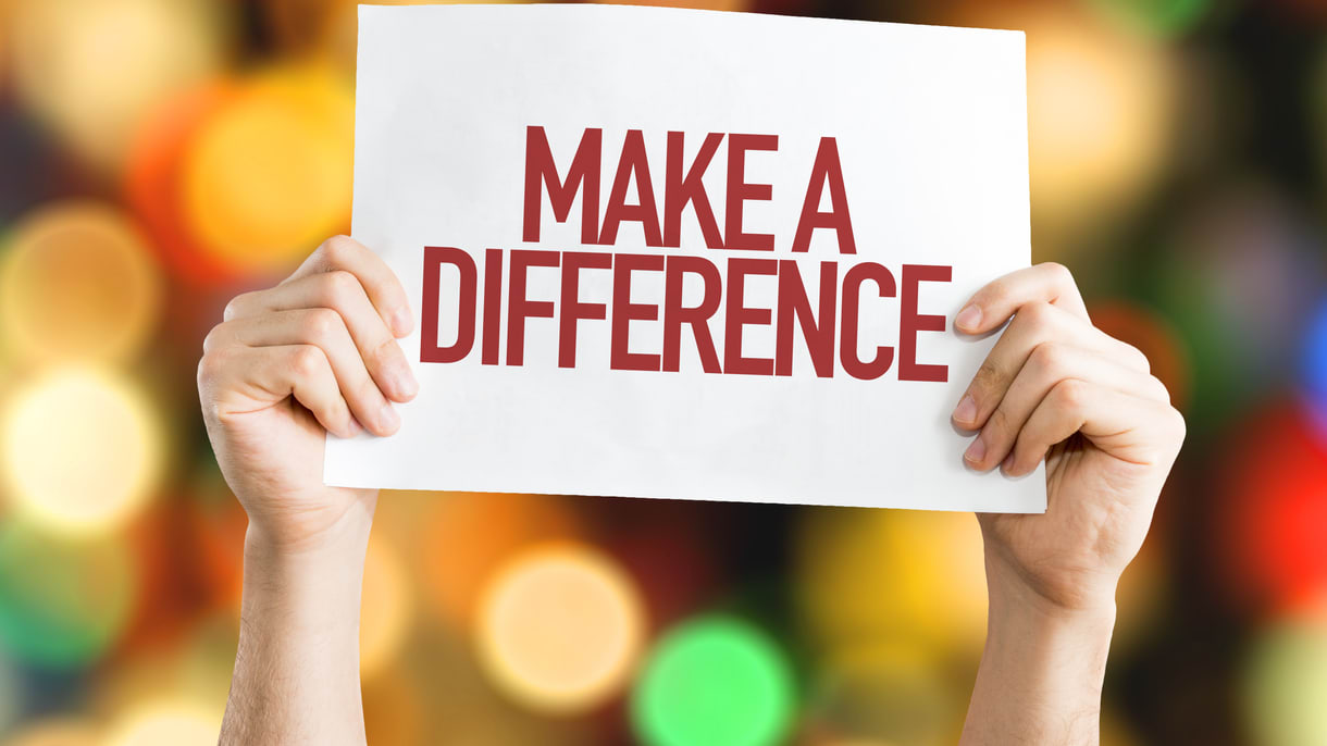 A person holding up a paper that says make a difference.