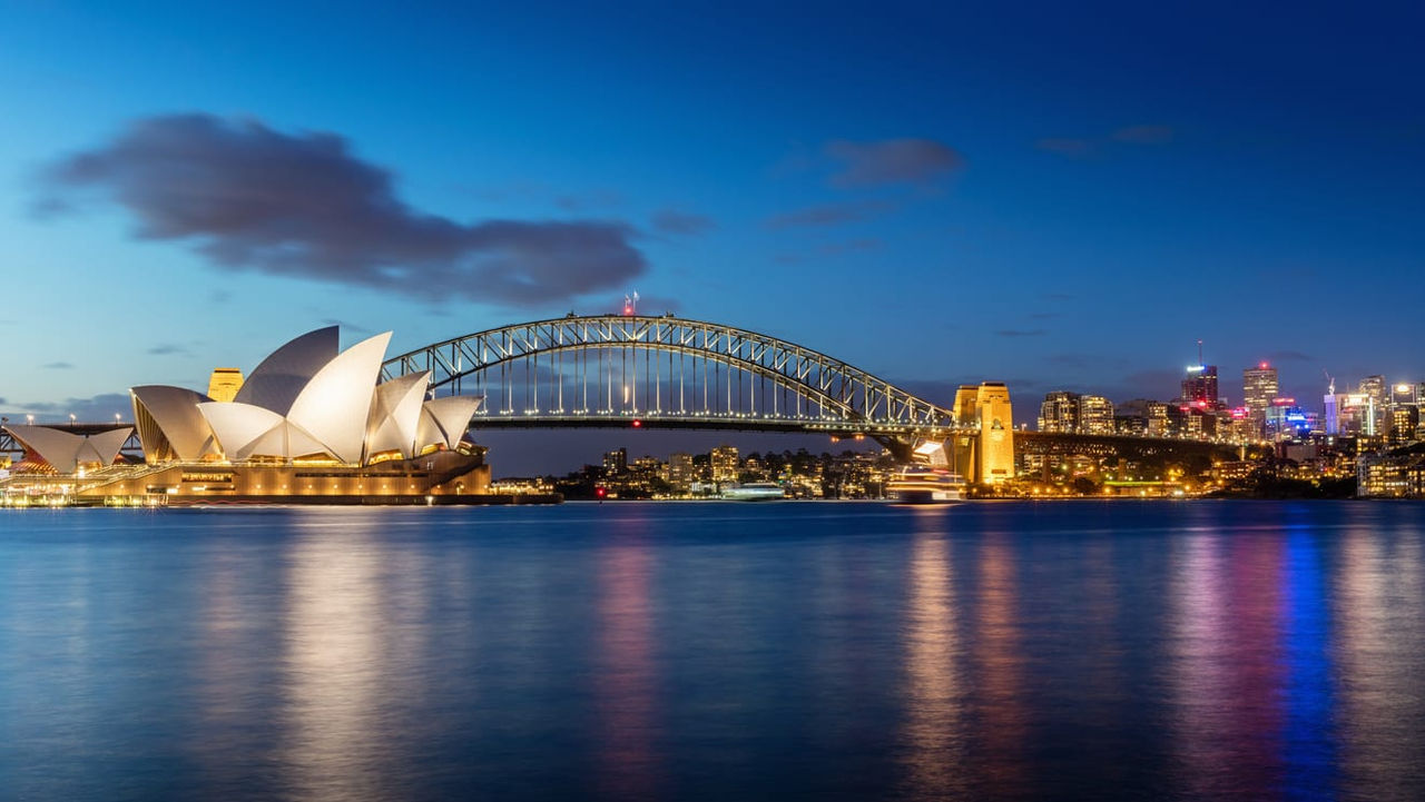 The sydney opera house and harbour bridge at dusk.