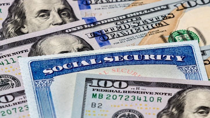 A social security card on a stack of money.