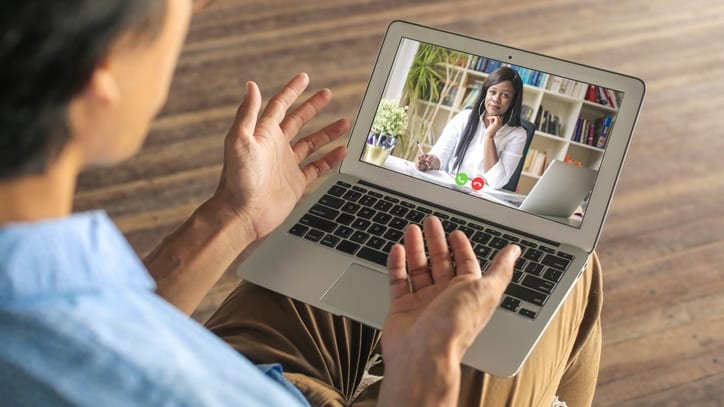 A man is using a laptop to make a video call to a woman.