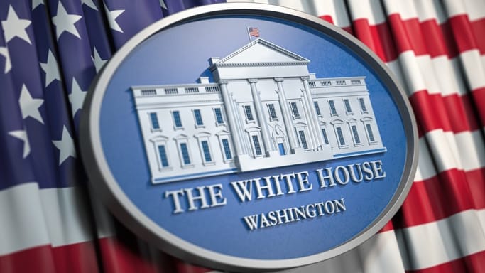 The white house logo in front of an american flag.
